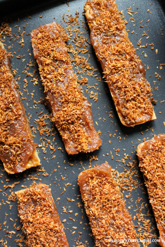 Caramel coconut candy bars right after the toasted coconut was sprinkled on top.