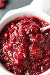 Spoon scooping out homemade cranberry sauce.