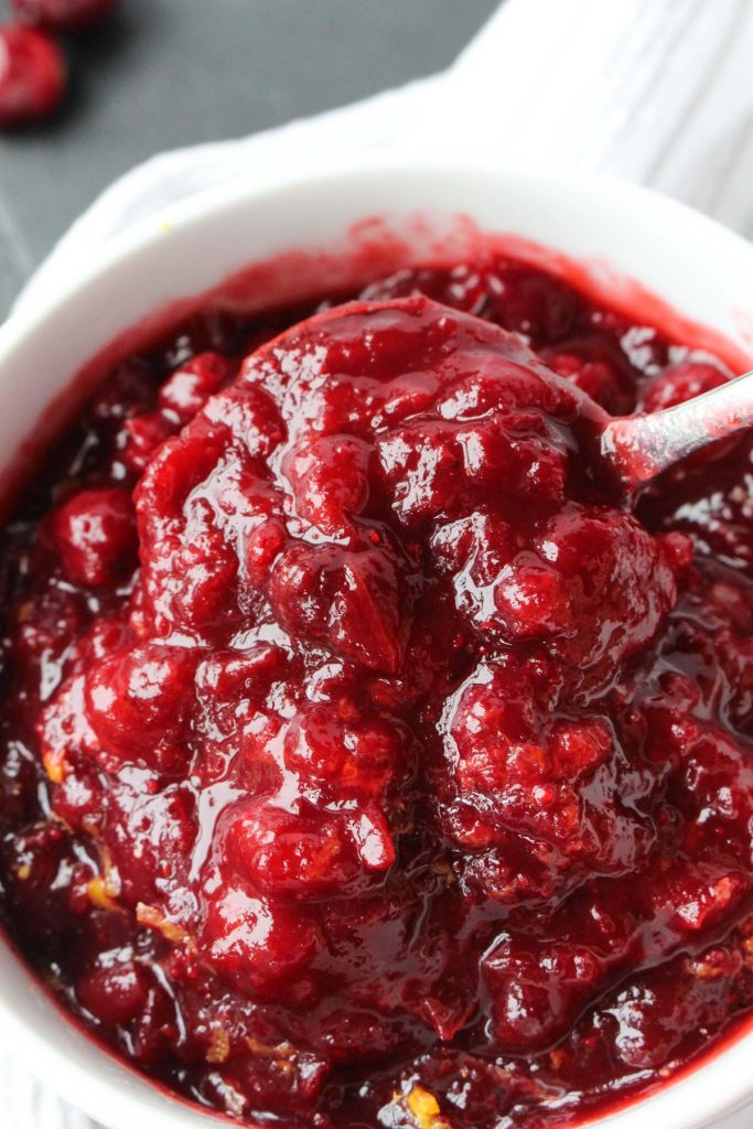 Spoon scooping out cranberry sauce.