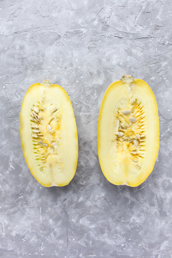 spaghetti squash cut in half with seeds inside.