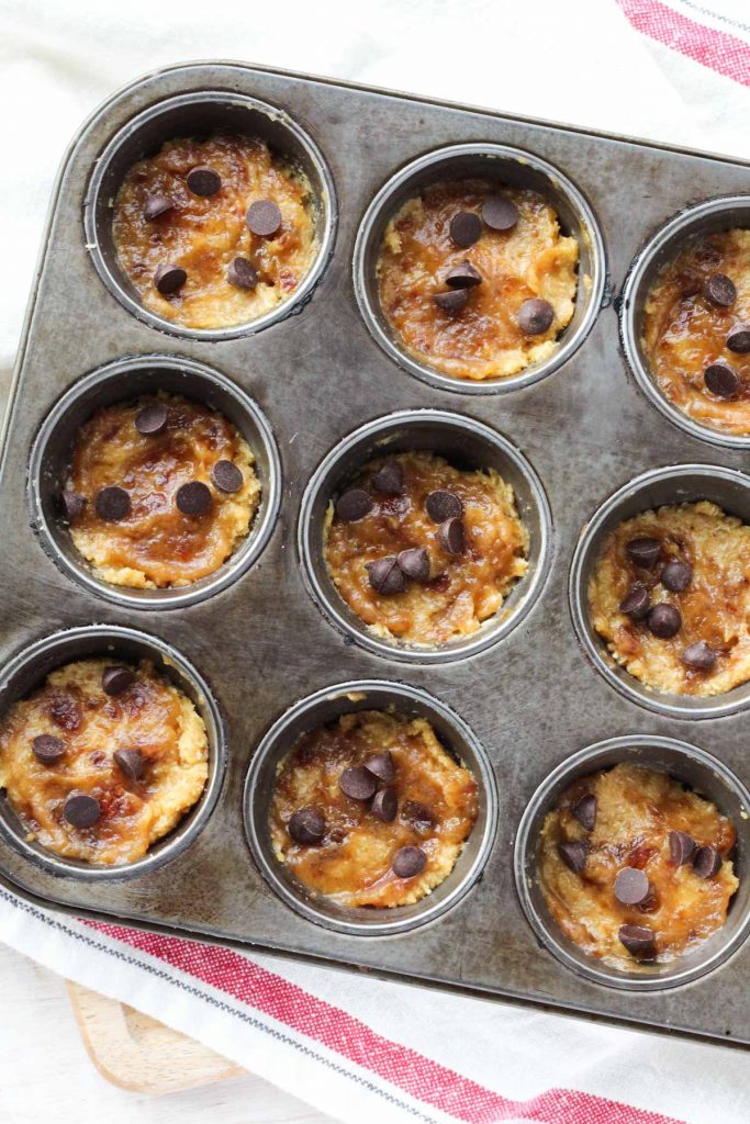 samoa muffins with the first layer of muffin, caramel, and chocolate chips.
