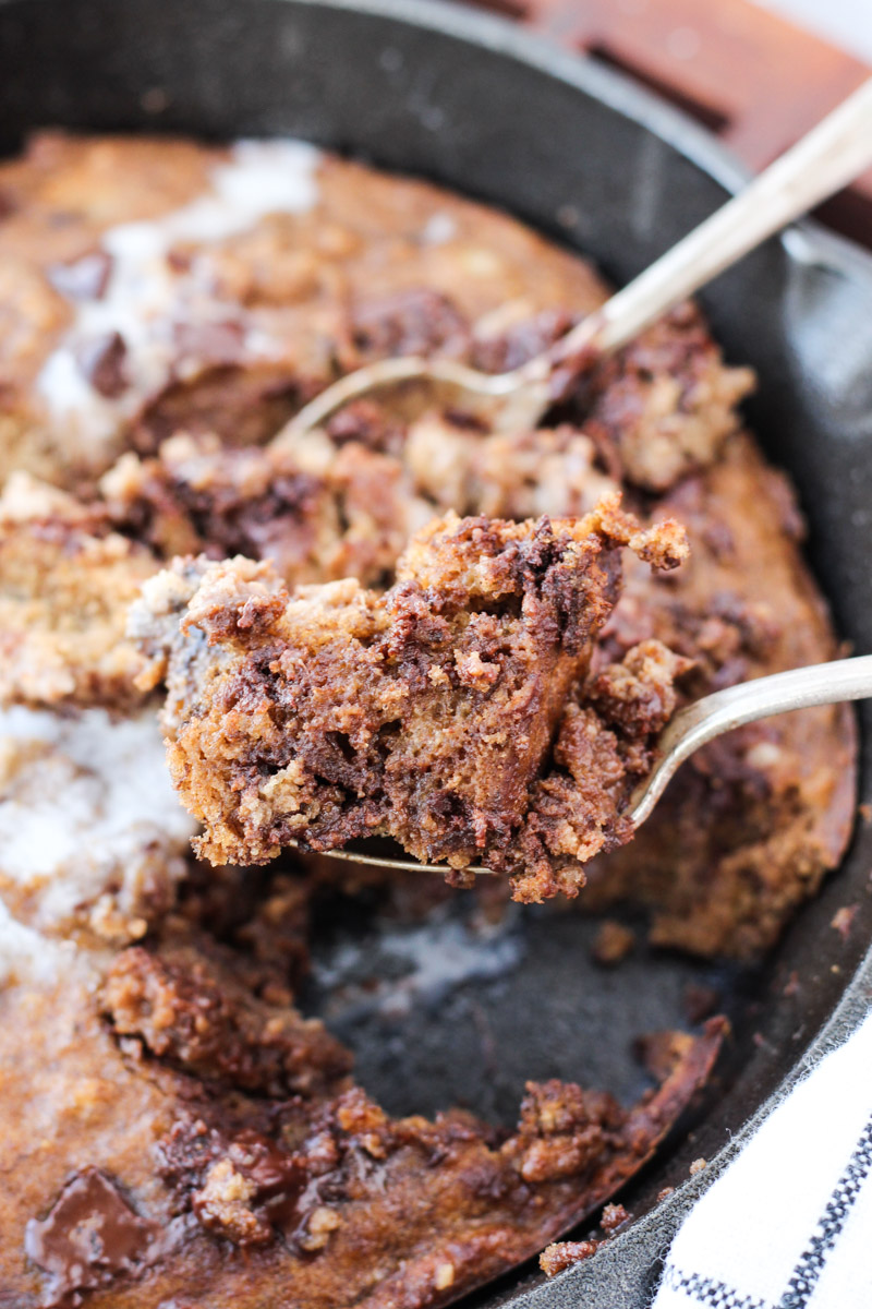 Fork holding up big bite of cookie skillet.