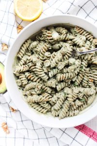 creamy walnut pesto in a large bowl with lemon slices around the outside.