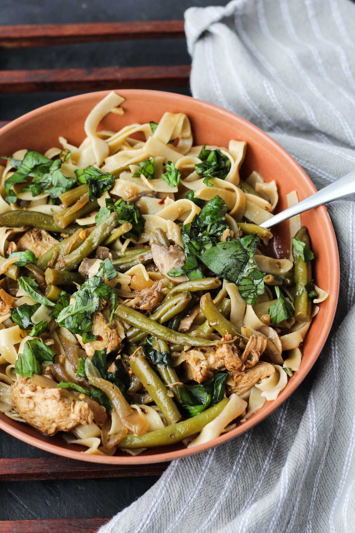 Close up picture of balsamic mushroom sauce dinner over gluten-free fettuccine and topped with fresh basil.