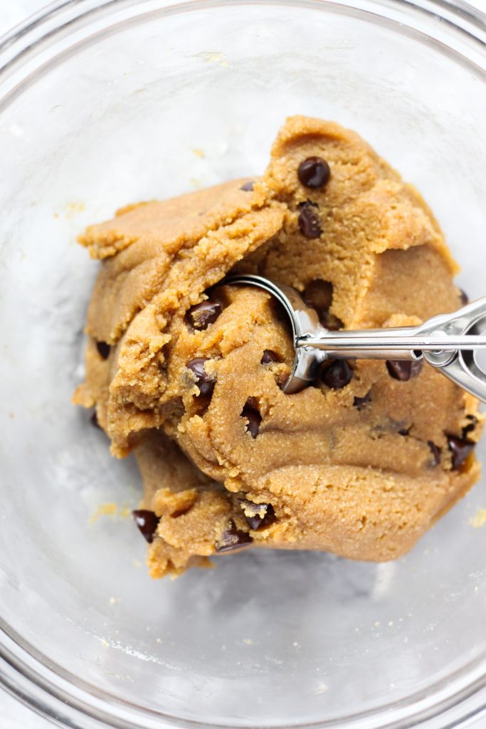 Scooping dough out of the bowl.