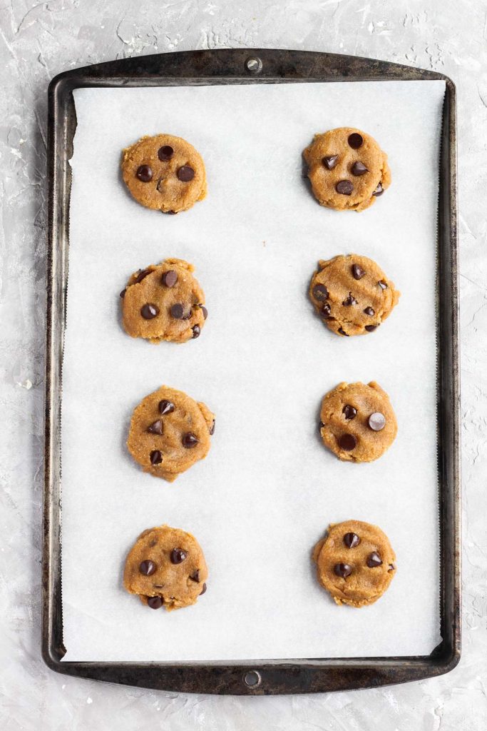 Cookies on baking sheet pressed into a cookie shape.
