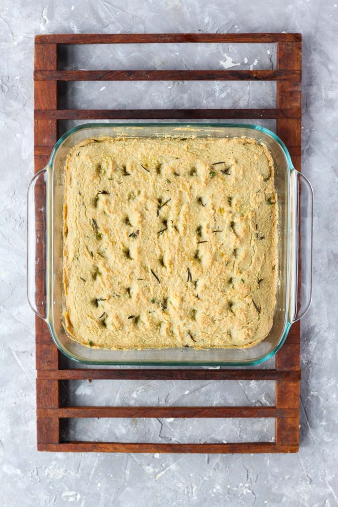 Bread in baking dish on cooling rack.