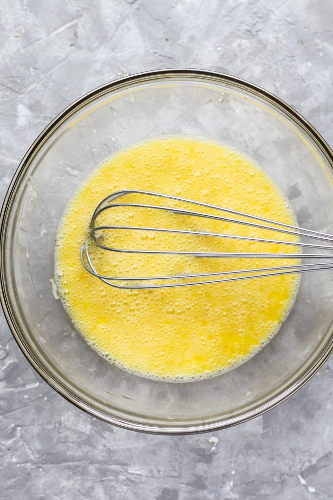 Wet ingredients in a mixing bowl with a whisk.