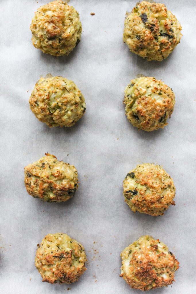 Golden brown meatballs on baking sheet.