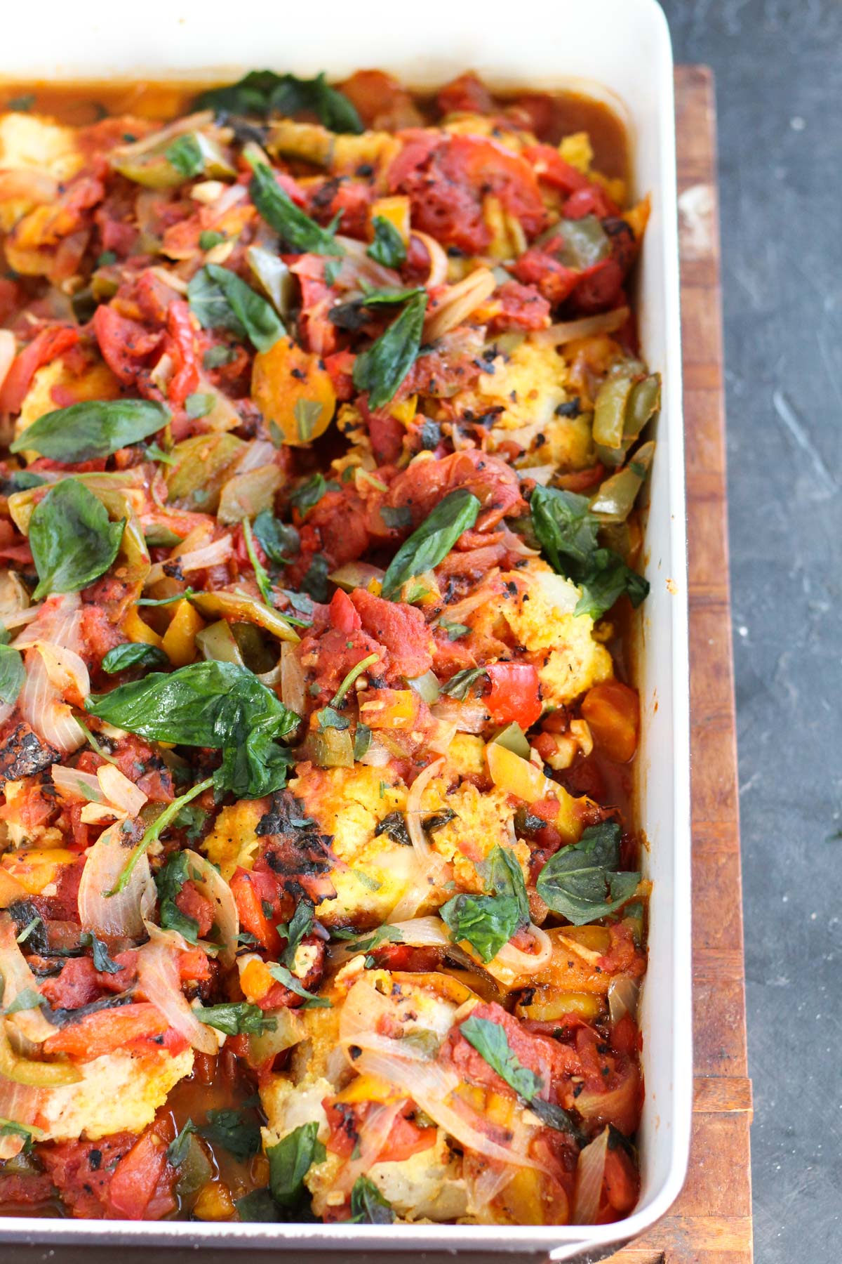 Chicken cacciatore in baking dish topped with fresh basil.