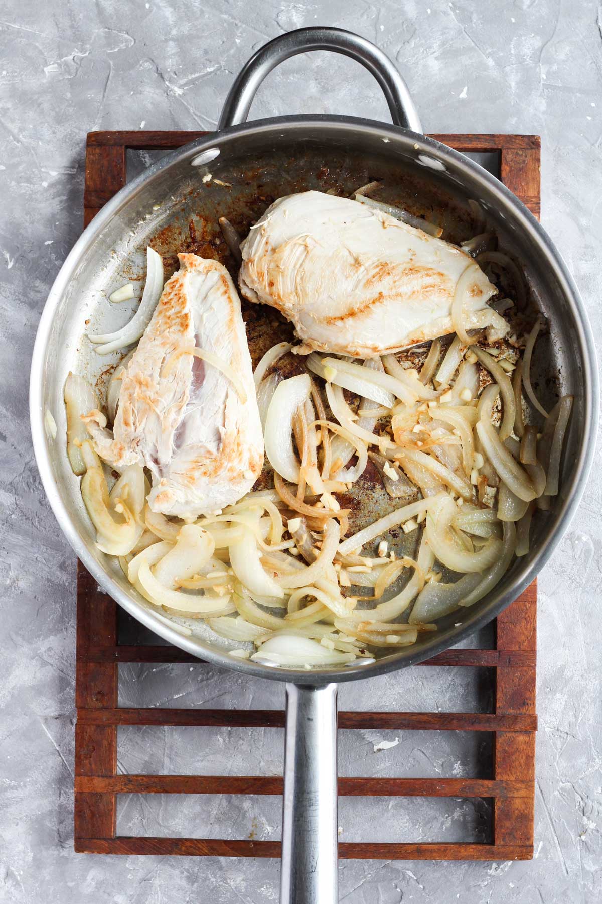 Chicken, onions, and garlic cooking in the pan.