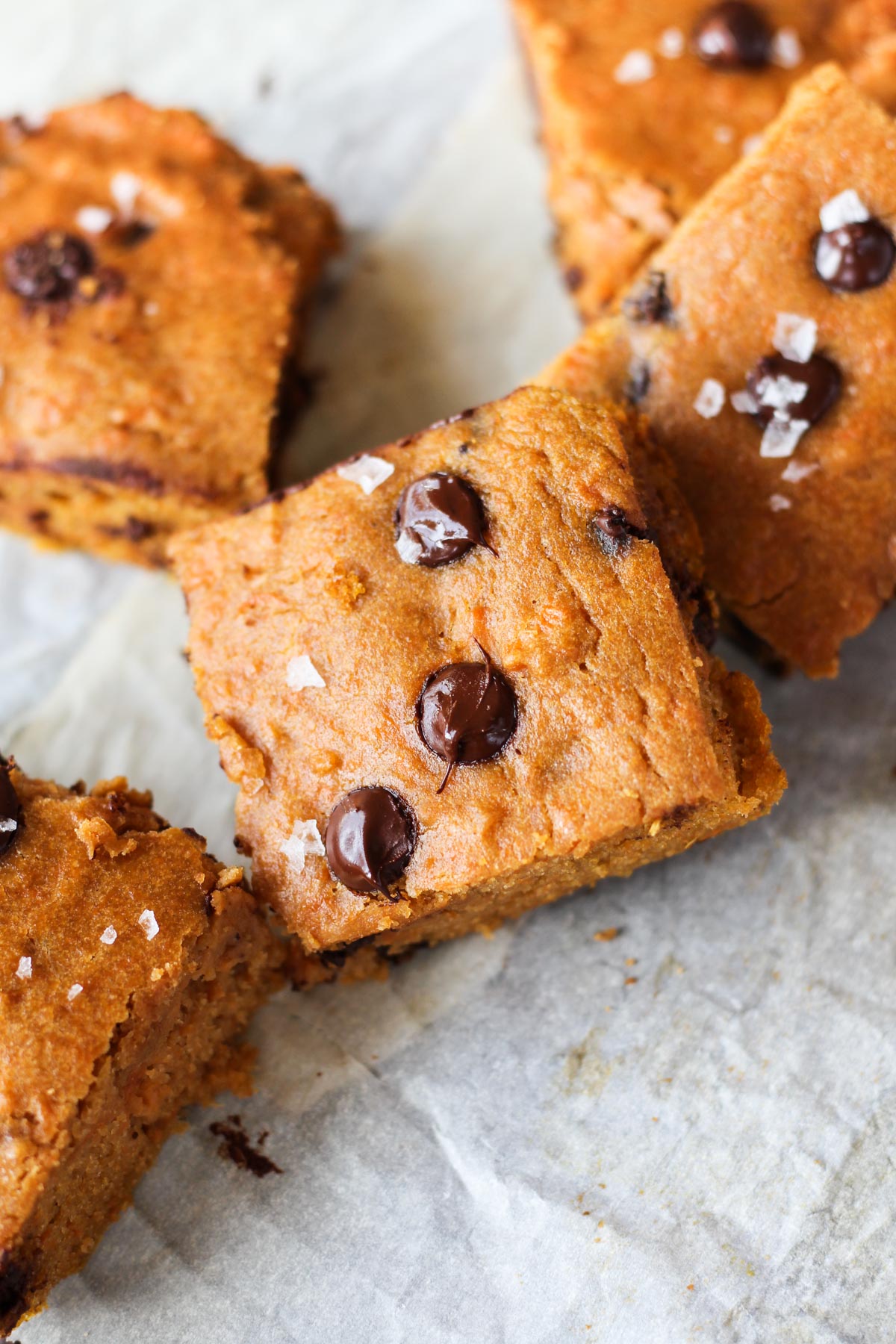 Blondies leaning up against each other on parchment paper.