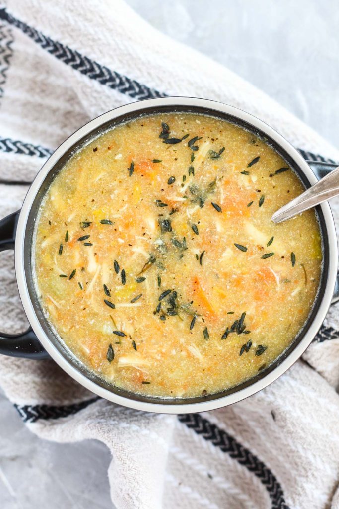 Bowl of soup with fresh thyme on top.
