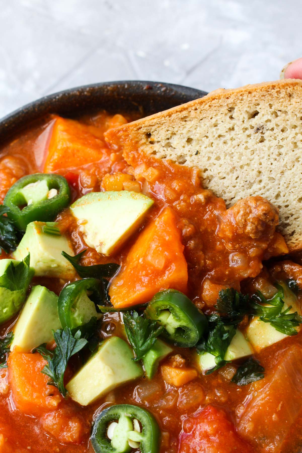 Bread dipping in chili.