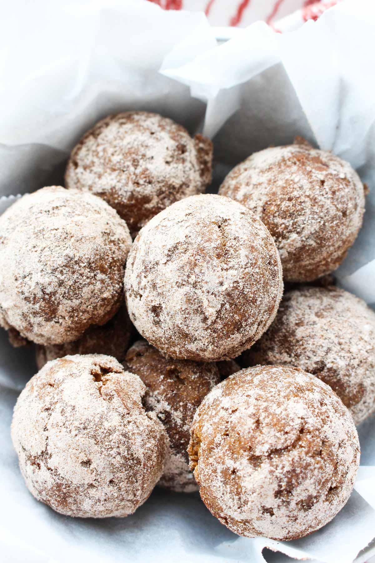 Donut holes in a parchment paper lined bowl.