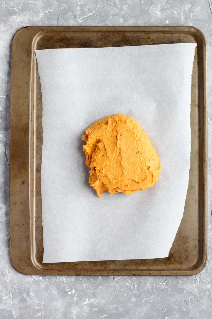 Dough on parchment paper lined baking sheet.