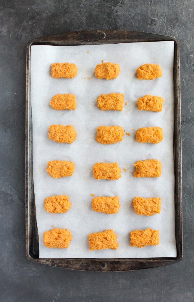 Sweet potato tots rolled out on baking sheet.