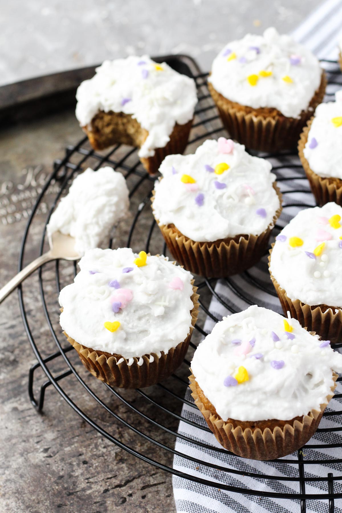 Frosted cupcakes on a metal rack.