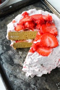 Overhead shot of gluten-free lemon cake with fresh strawberries on top.