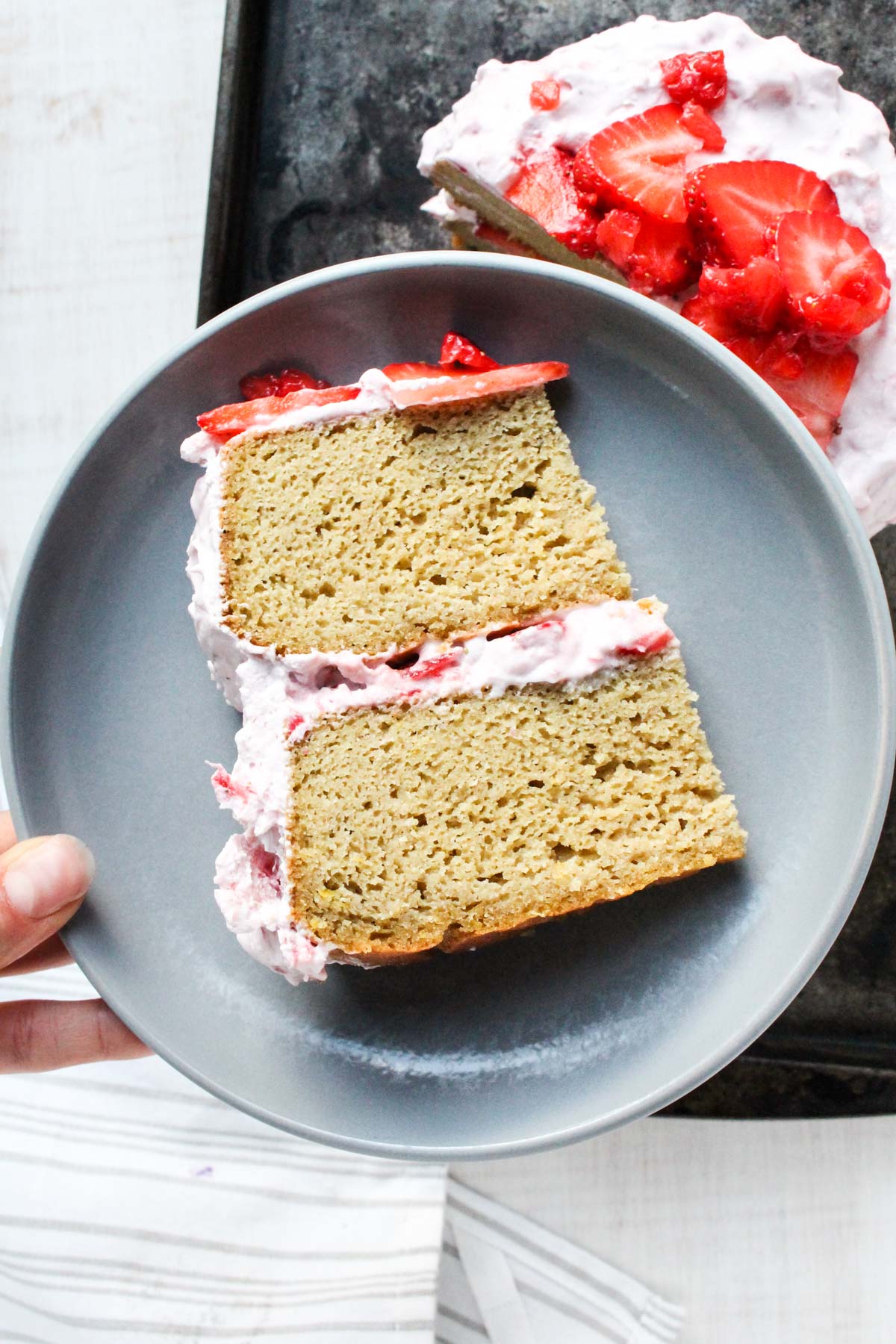 Slice of lemon cake on a grey plate.