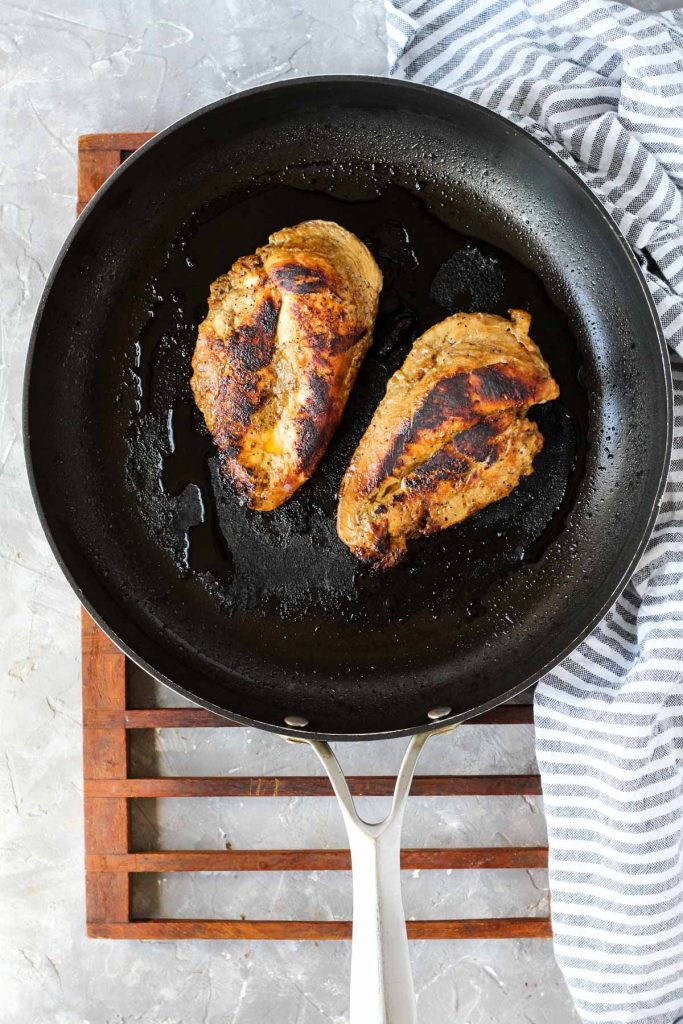 Chicken fully cooked on frying pan.
