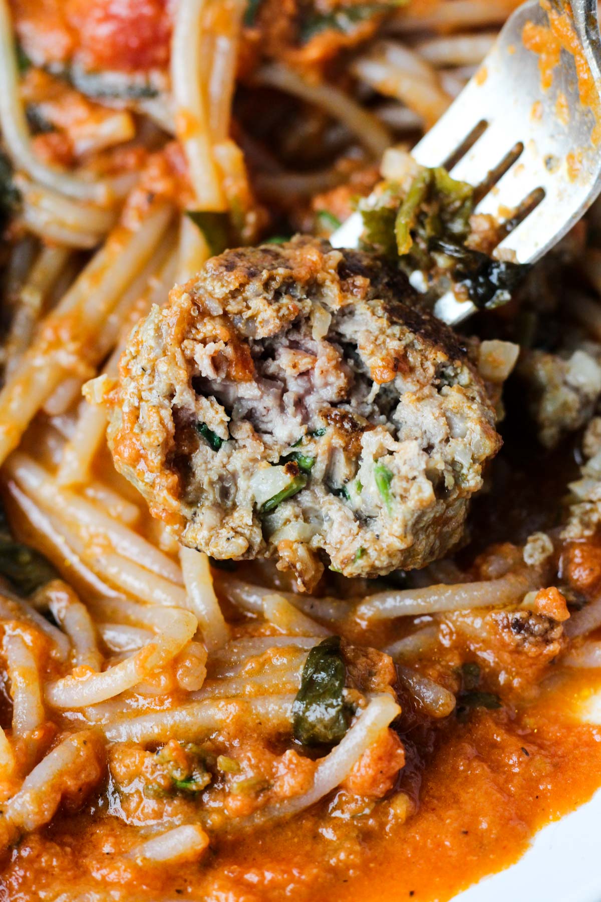 Close up shot of a meatball with a big bite taken out.