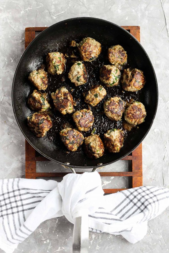Overhead shot of cooked meatballs in skillet.