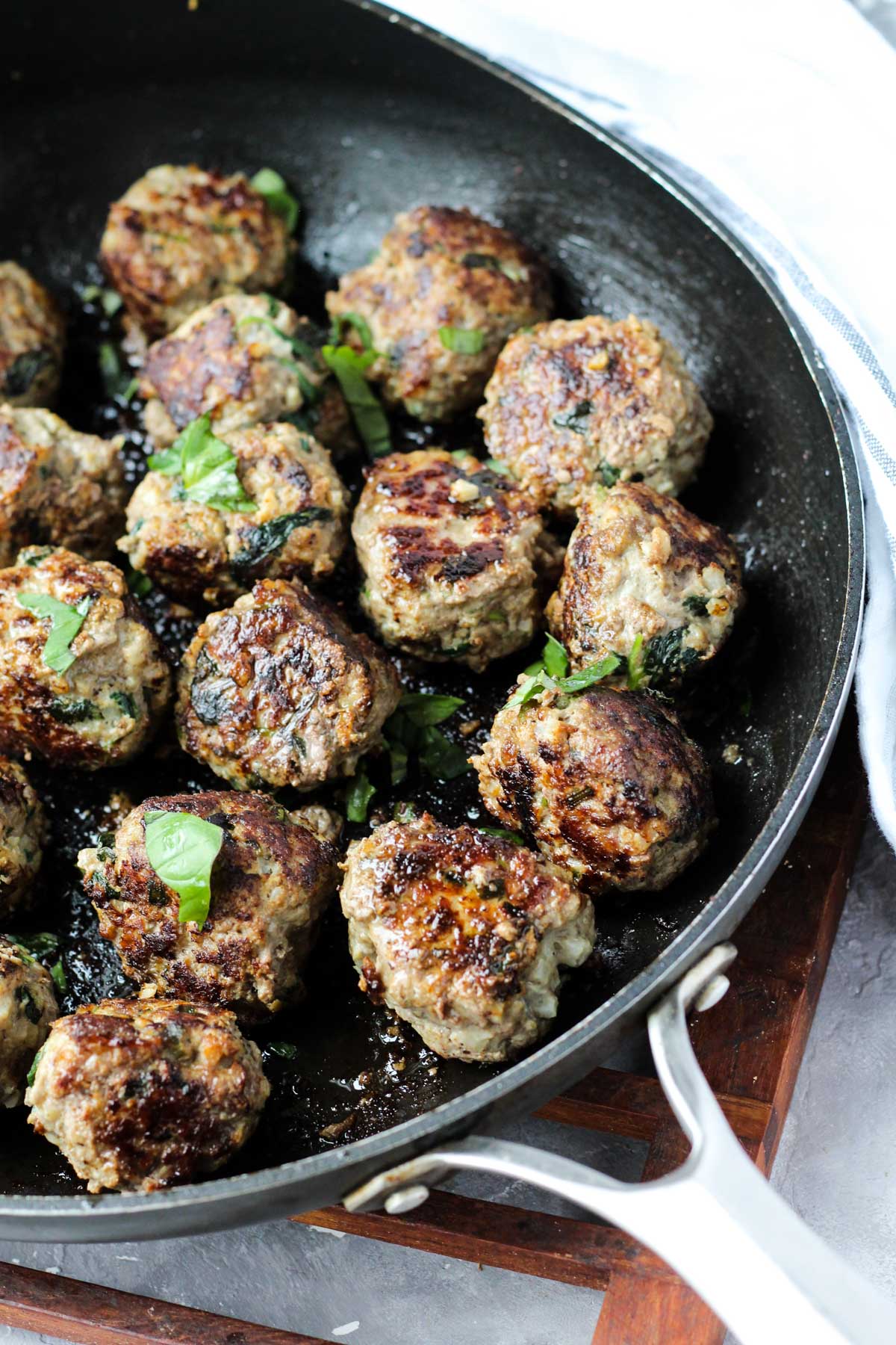 Skillet with sautéed meatballs.