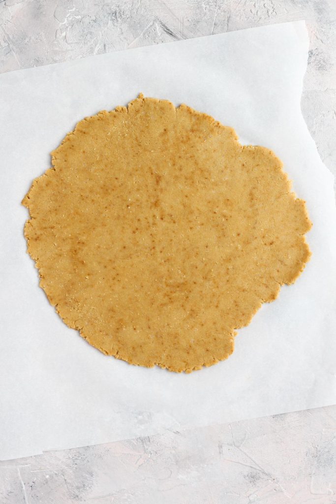 Dough rolled out on parchment paper.