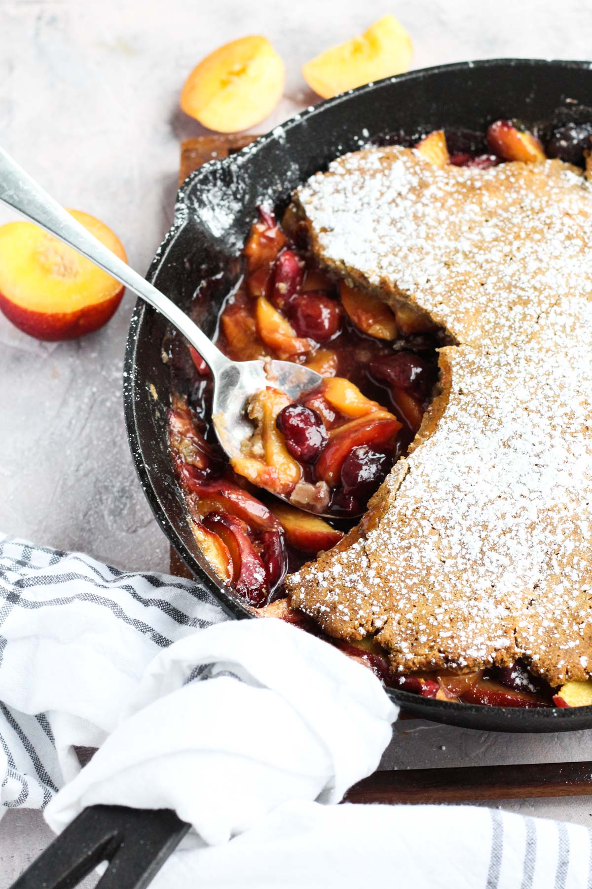 Side angle of cobbler with a spoon scooping out fruit.