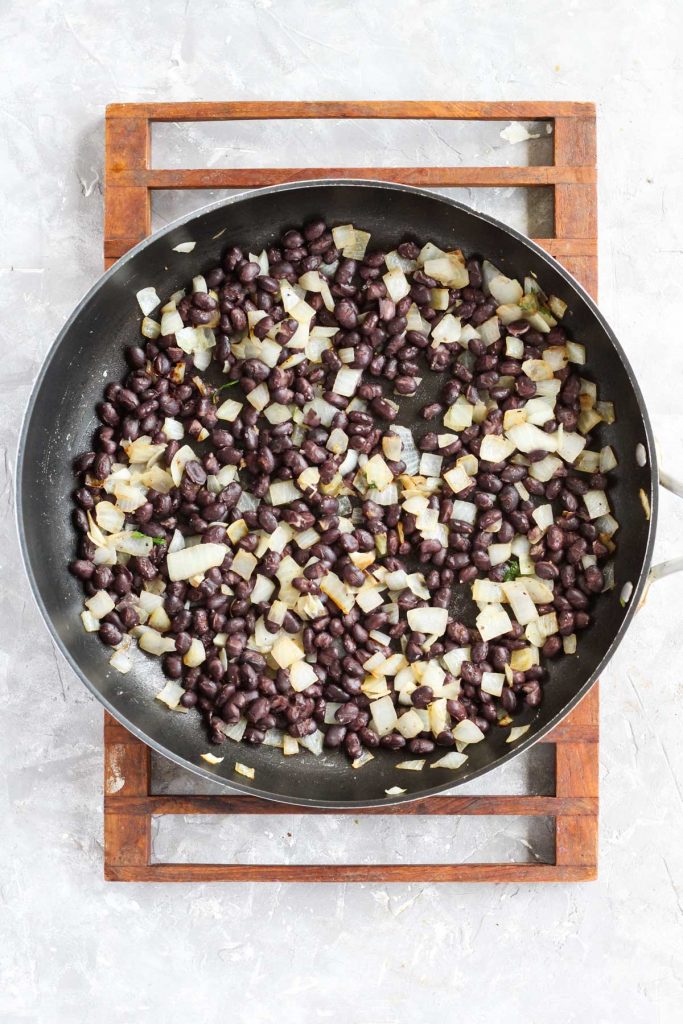 Frying pan with beans and onions.