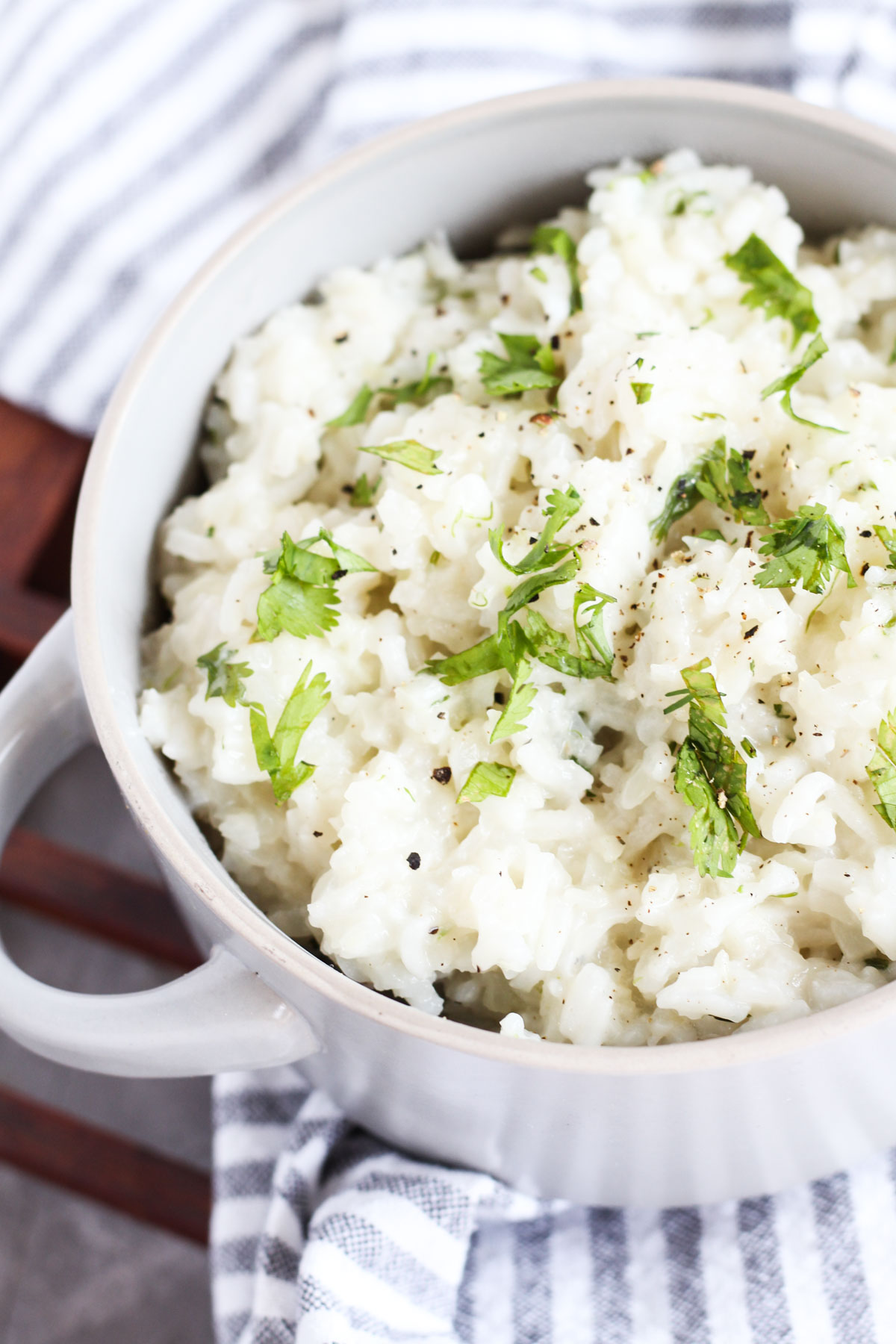 Cilantro rice in a ceramic bowl with fresh cilantro on top.