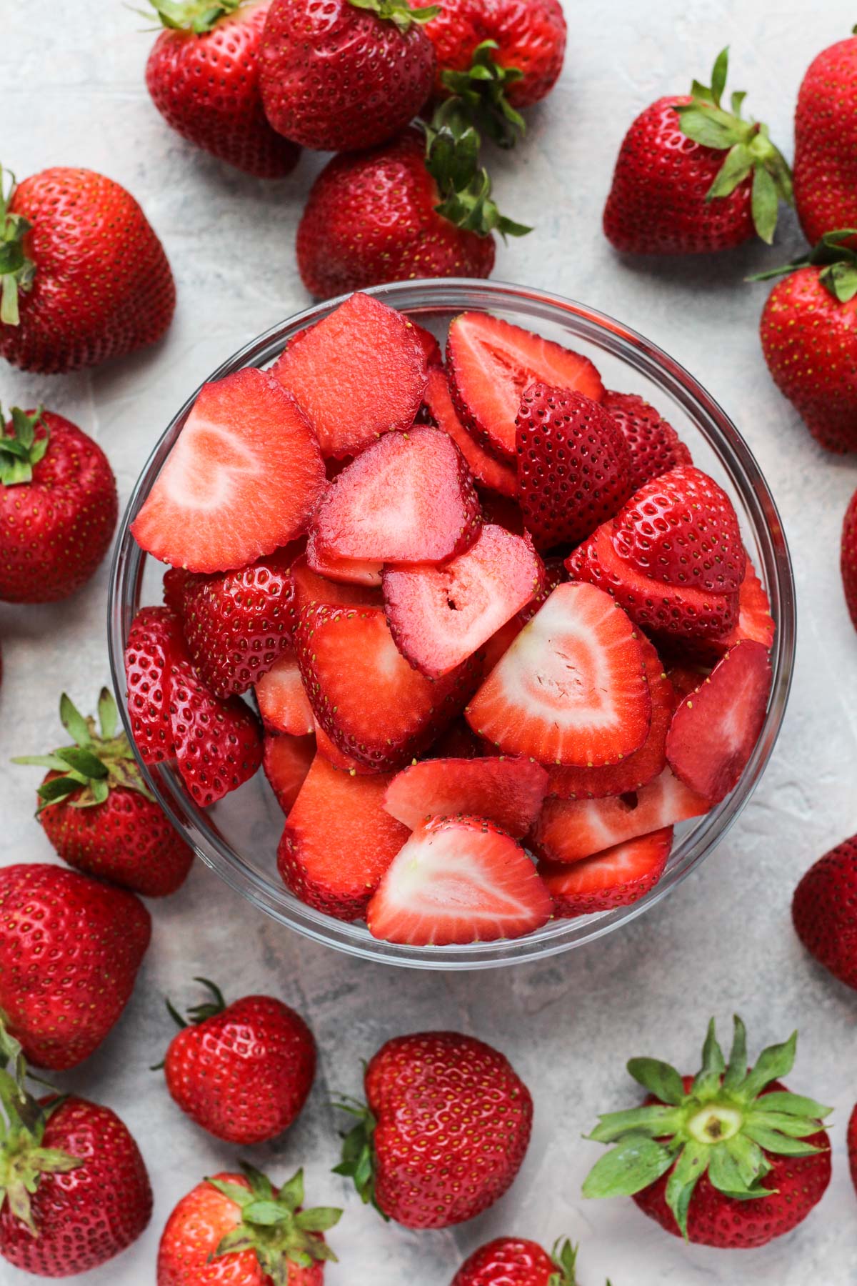 Overhead shot of sliced strawberries in a bowl.
