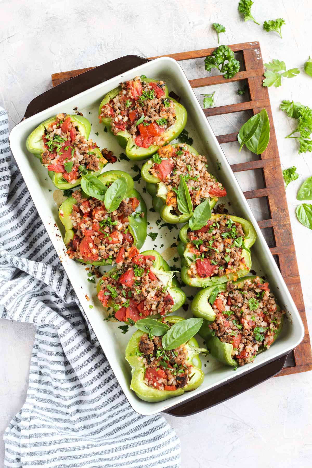 Overhead shot of baked stuffed peppers topped with fresh basil.