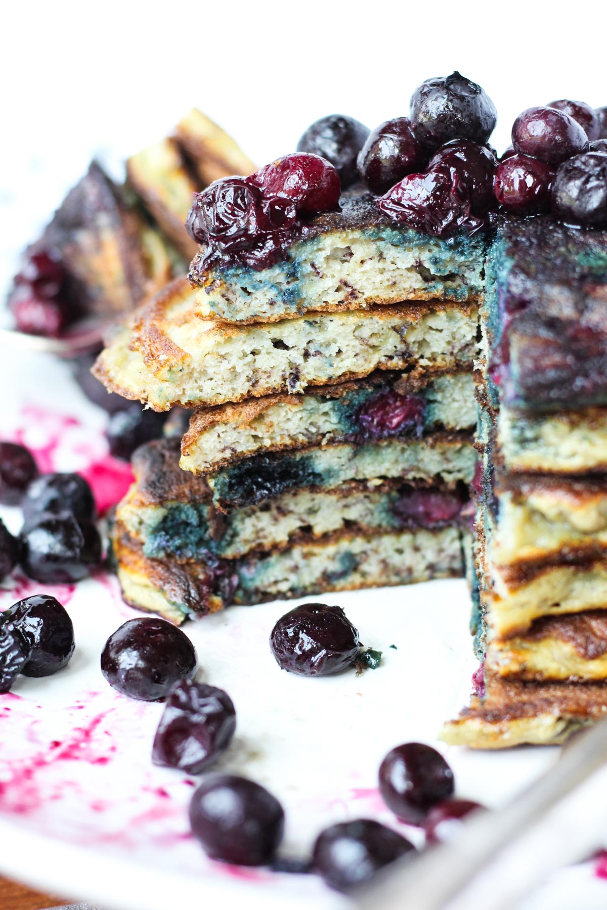 Stack of blueberry pancakes with a bite cut out.