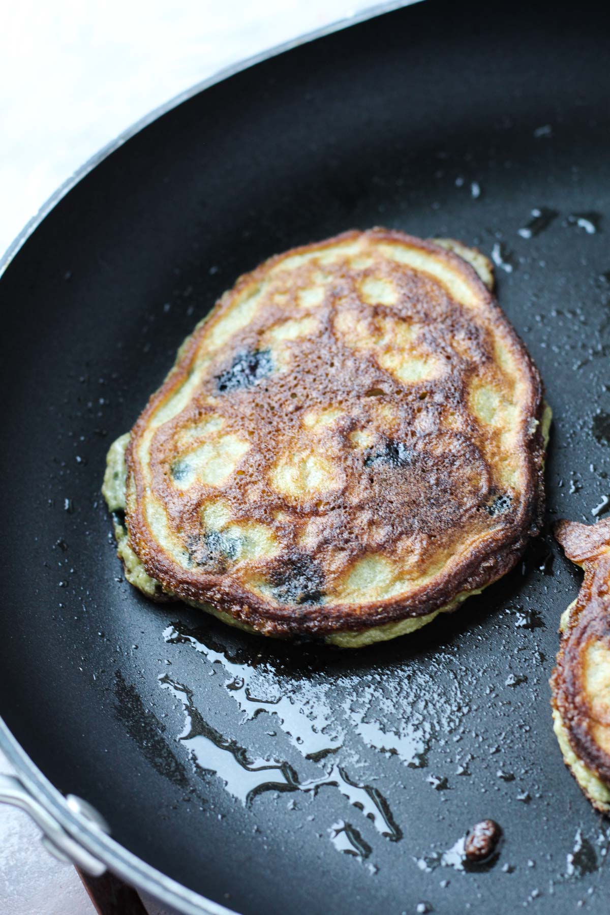 Pancake cooking on a frying pan.