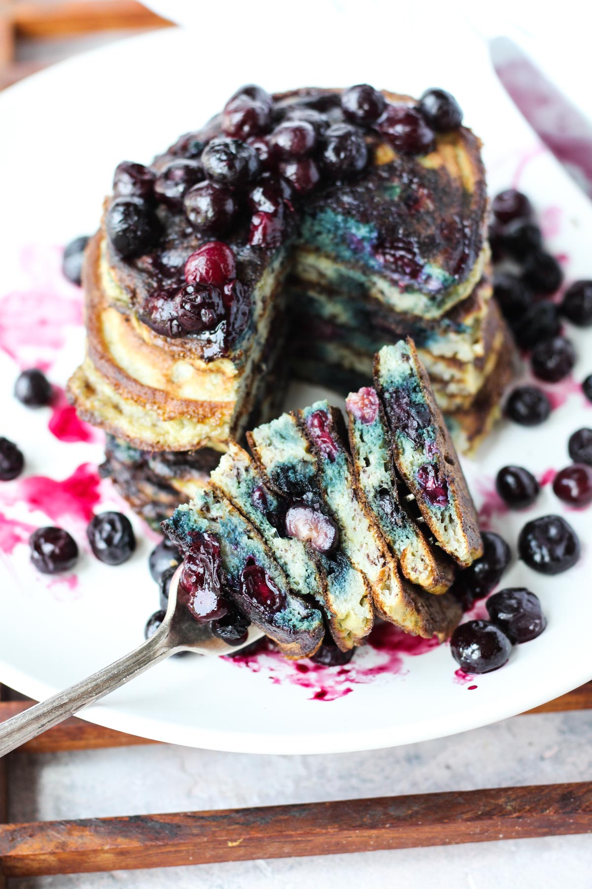 Plate of pancakes with a big bite on a fork.
