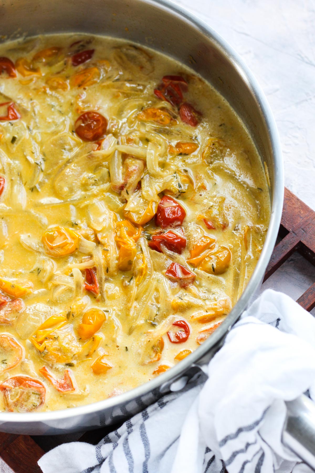 Creamy cherry tomato sauce simmering in pan.