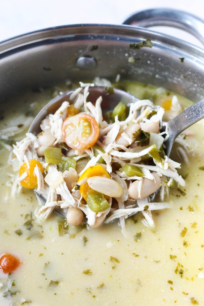 Ladle scooping out white chicken chili.