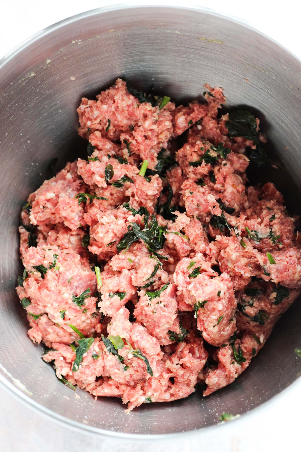 Meatball mixture in metal bowl.