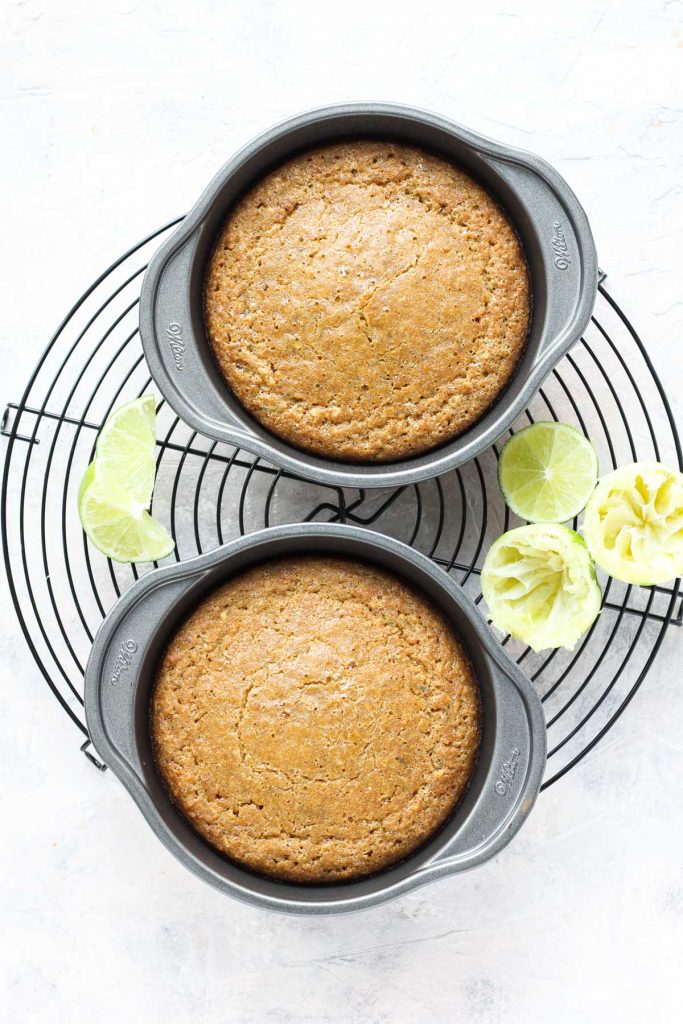 Two small cakes cooling on metal rack.