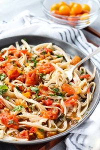 Spaghetti and sauce on a plate with a white towel on the side.