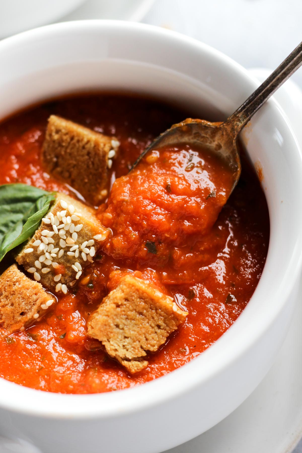 Spoon scooping out tomato basil soup.