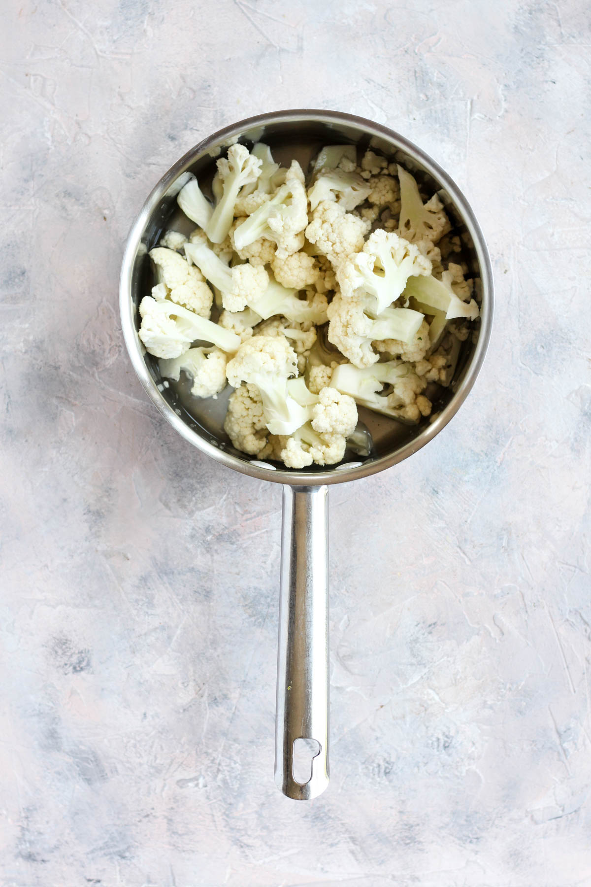 Cauliflower florets in a sauce pan.