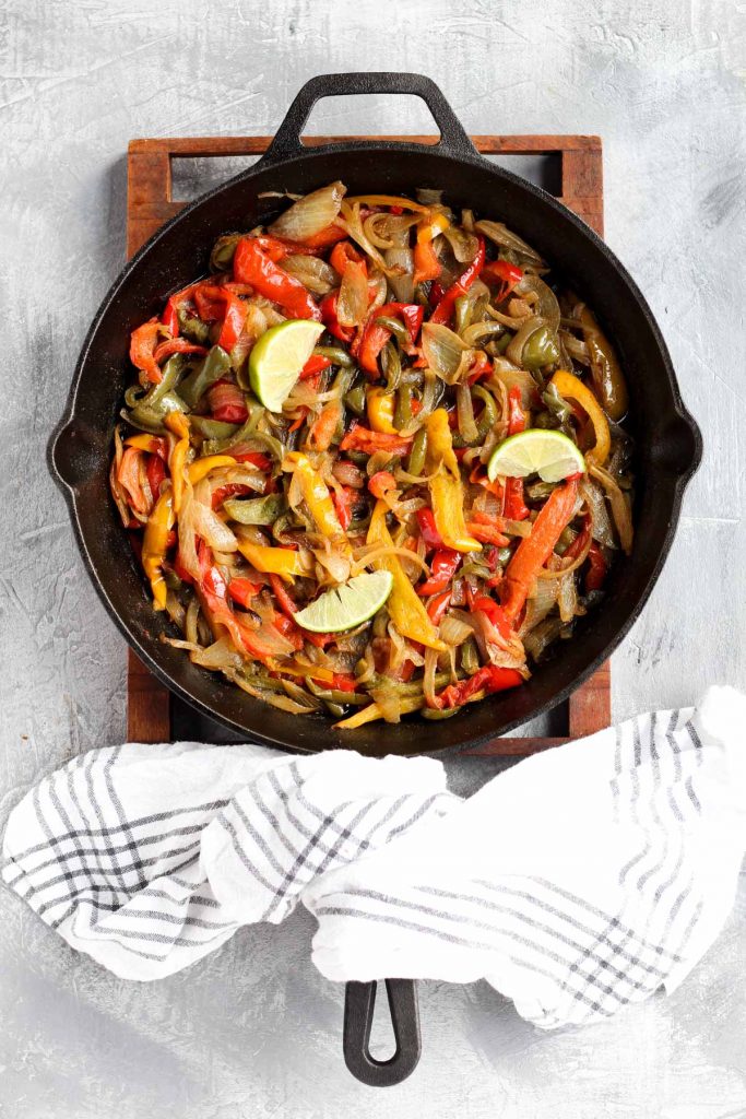 Overhead shot of cooked peppers and onions in pan.