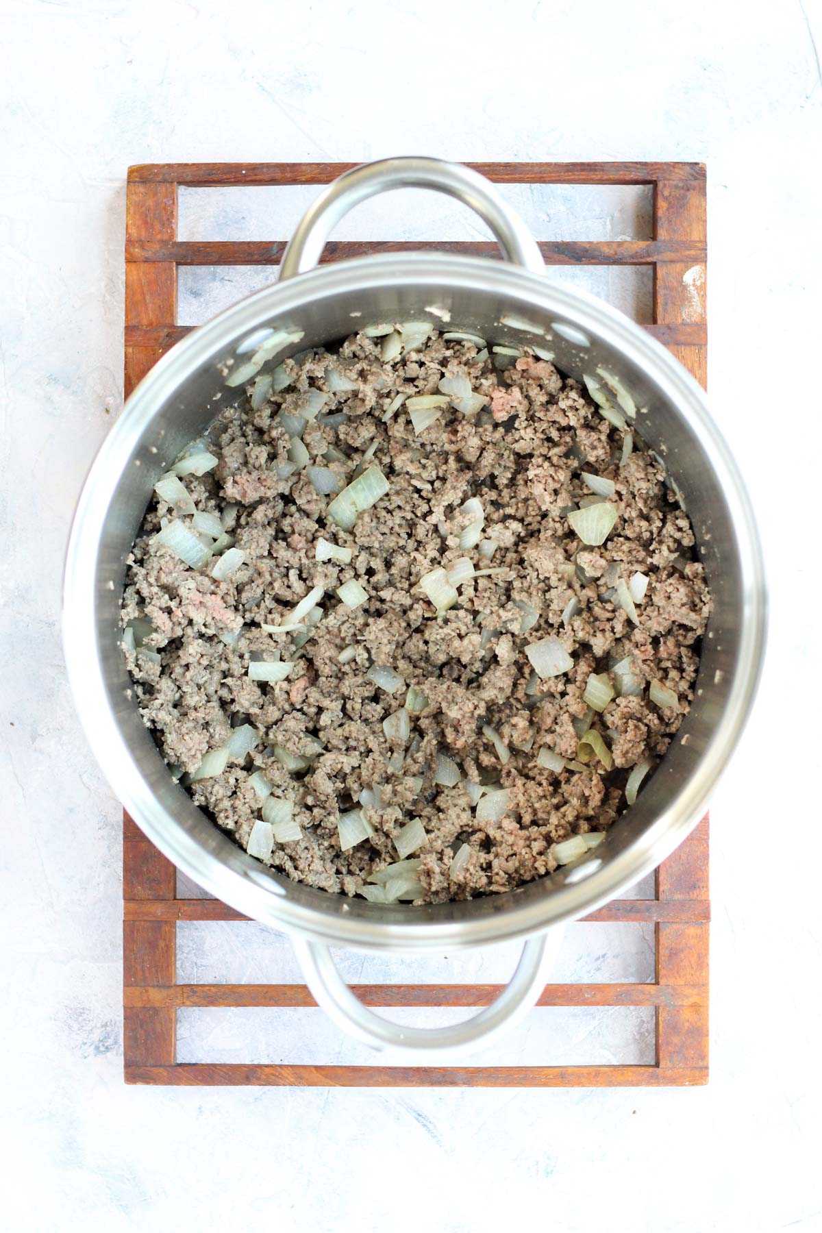 Large pot with ground beef and onions.