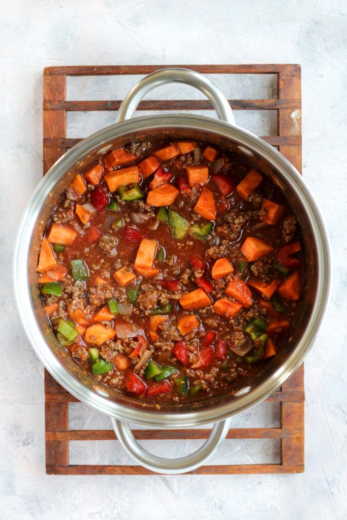 Vegetables and tomatoes in pot before cooking.