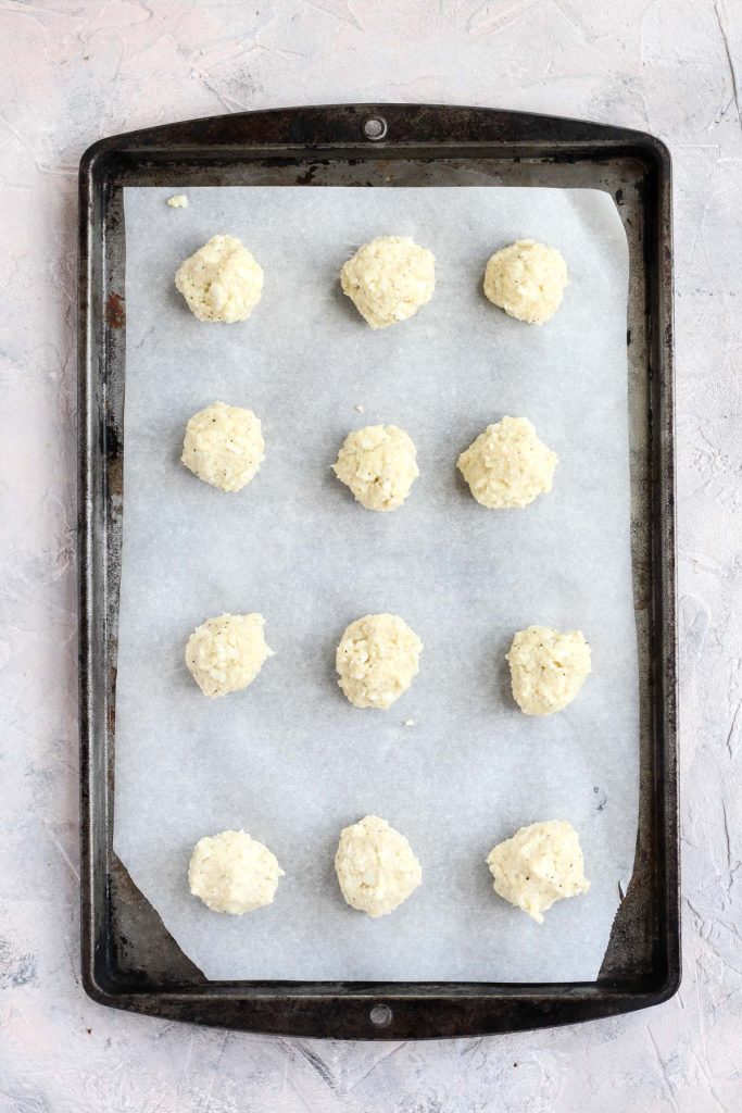 Meatballs on baking sheet with parchment paper.