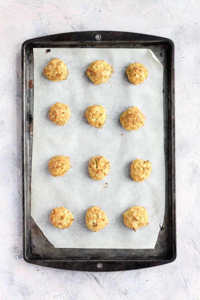 Baked meatballs on on a baking sheet.