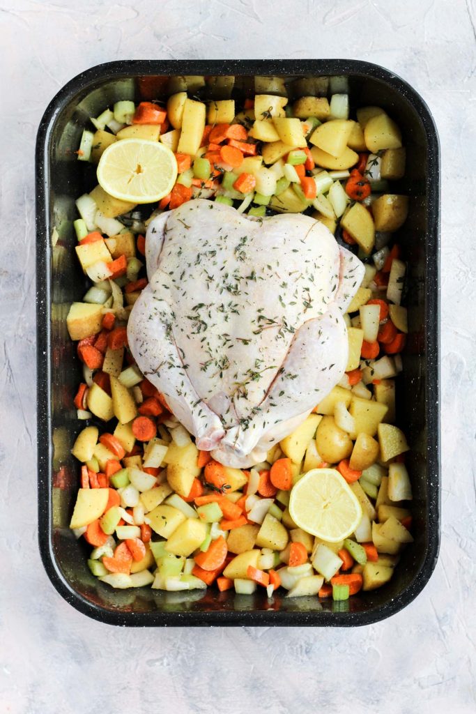 Pan with whole chicken and vegetables before going into the oven.